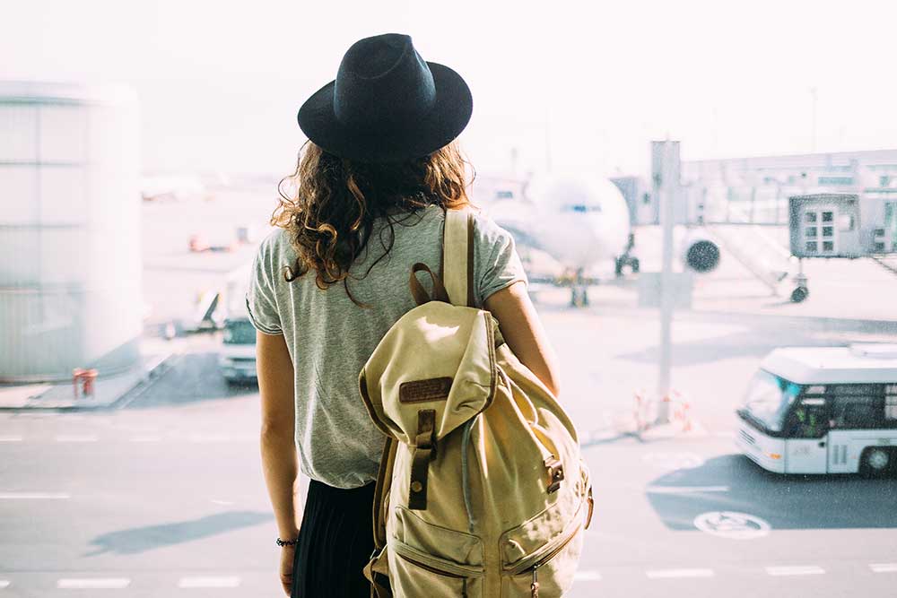 girl-with-backpack-at-international-airport 