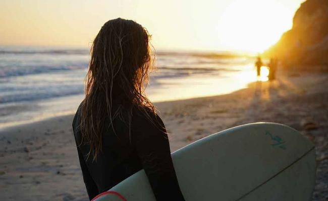 girl-holding-surfboard-on-the-beach 