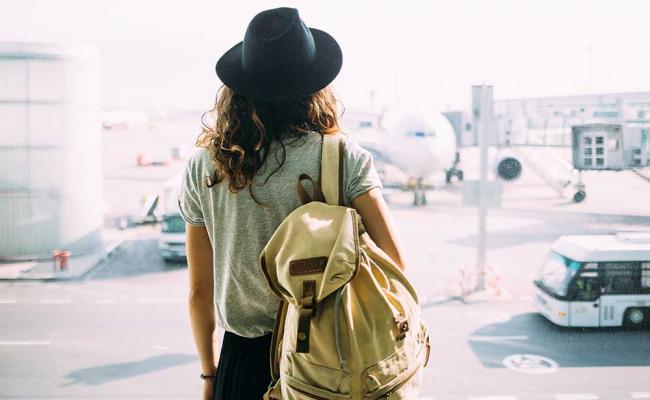 girl-with-backpack-at-international-airport 